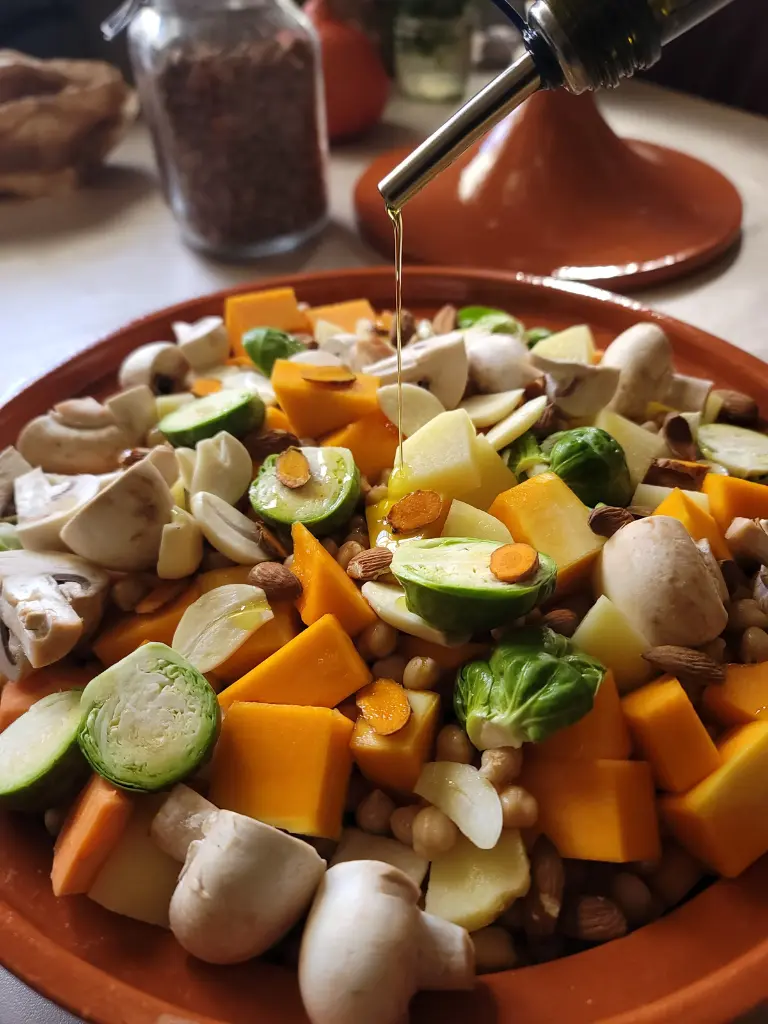 Tajine aux légumes d'automne assaisonné avec de l'huile d'olive et des épices réconfortantes.